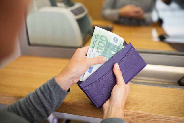 hands with money at bank or currency exchanger